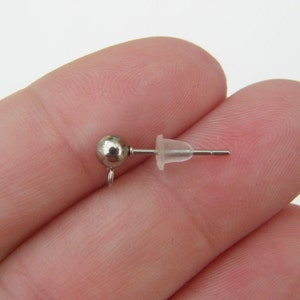 May include: A silver earring post with a small round ball at the top and a clear plastic stopper.