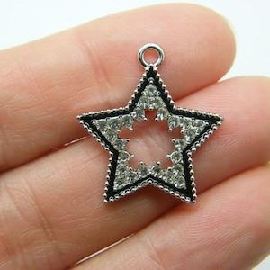 May include: Silver-toned star-shaped pendant with a black outline and clear rhinestones around the edge.