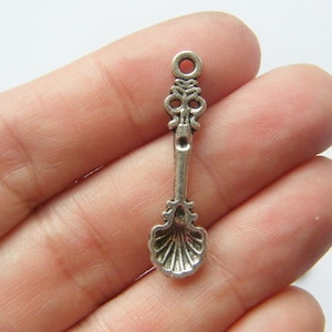 Op de afbeelding: Zilveren lepeltje bedel met een sierlijk ontwerp. De lepel heeft een ronde kom en een decoratief handvat. De bedel is perfect om een ​​vintage touch toe te voegen aan sieraden of knutselwerk.