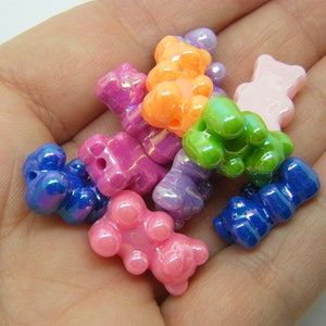 May include: Assortment of colorful gummy bear shaped beads with iridescent finishes. The beads are in various colors including pink, blue, green, orange, and purple.