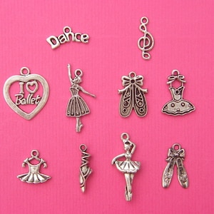 Puede incluir: Una colección de dijes de metal plateado con temática de ballet. Los dijes incluyen una bailarina, zapatillas de ballet, un vestido, un corazón con las palabras "Me encanta el ballet", una nota musical y la palabra "Danza".
