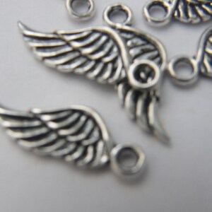 May include: Silver metal angel wing charms with a loop for attaching to jewellery or crafts.