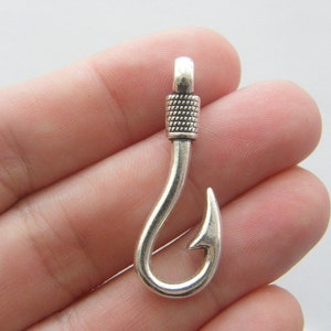 May include: Silver-toned metal fishing hook charm with a textured design. The hook is open and has a sharp point.