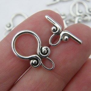 Pu&ograve; includere: Chiusure in metallo argentato con un design a spirale decorativo. Le chiusure sono progettate per essere utilizzate per la creazione di gioielli.