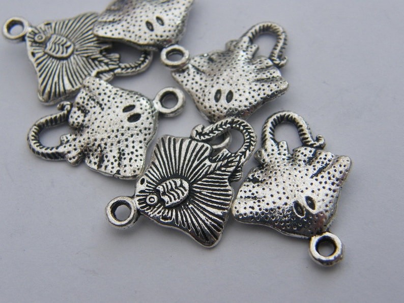 K&ouml;nnte beinhalten: Sechs silberfarbene Metall-Anh&auml;nger in Form von Rochen. Jeder Anh&auml;nger hat eine &Ouml;se zum Anbringen an einer Halskette, einem Armband oder anderem Schmuck.