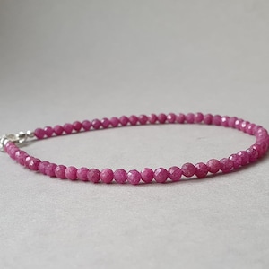 Peut inclure: Un bracelet délicat composé de petites perles de rubis facettées, de couleur rose-rouge vif. Les perles sont enfilées avec un fermoir en argent. Le bracelet est conçu pour être porté autour du poignet.