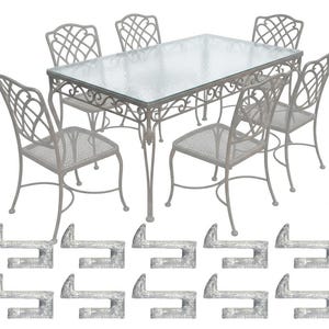 May include: A light gray outdoor dining set with a rectangular glass-top table and six matching chairs. The chairs and table frame have an ornate, openwork design. Below are ten matching metal hooks.