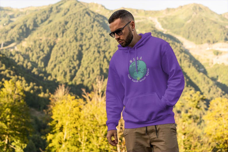 Peut inclure: Sweat-shirt &agrave; capuche violet avec un graphique d'une terre verte et bleue avec le texte "MEGA Make Earth Great Again" imprim&eacute; sur le devant.