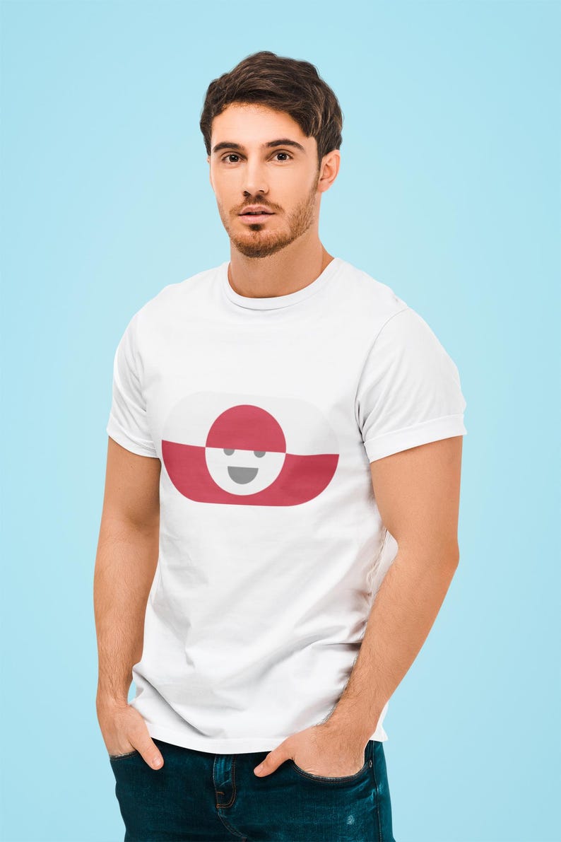 Peut inclure: T-shirt blanc avec un motif graphique ovale rouge et blanc avec un visage souriant. Le t-shirt est fait d'une mati&egrave;re douce et est port&eacute; par une personne aux cheveux fonc&eacute;s et &agrave; la barbe. Le fond est bleu clair.