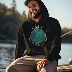 Peut inclure: Un sweat-shirt &agrave; capuche noir avec un graphique vert, bleu et blanc de la Terre. Le graphique comporte le texte "MEGA" au-dessus de la Terre et "Make Earth Great Again" autour de la Terre.