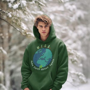 Peut inclure: Sweat-shirt &agrave; capuche vert avec un graphique d'une Terre bleue et verte avec le texte "MEGA Make Earth Great Again" imprim&eacute; sur le devant.