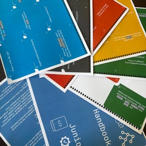 Puede incluir: Un conjunto de tarjetas did&aacute;cticas coloridas, encuadernadas con espiral negra, con texto y diagramas. Las tarjetas son azules, rojas, amarillas, verdes y negras, con el t&iacute;tulo "Junior Handbook" visible en una tarjeta azul. Las tarjetas son para entrevistas Java.