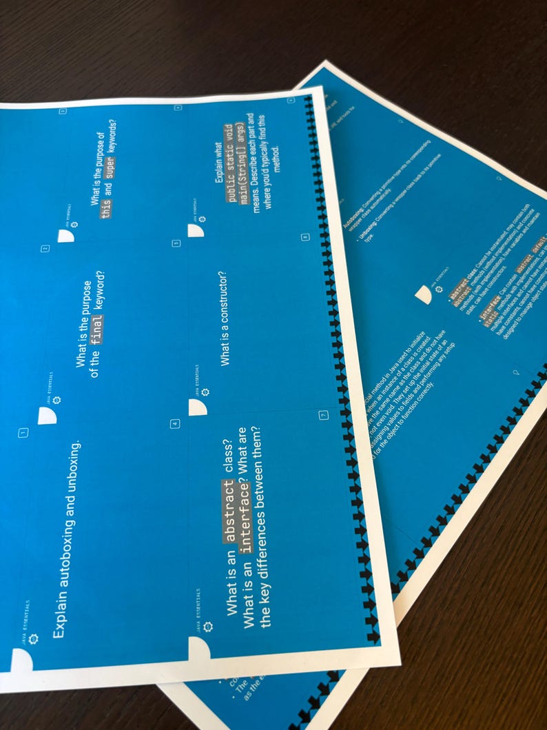 Puede incluir: Varios documentos educativos azules con texto blanco est&aacute;n apilados sobre una superficie marr&oacute;n oscuro. Los documentos est&aacute;n encuadernados en espiral y contienen preguntas sobre conceptos de programaci&oacute;n.