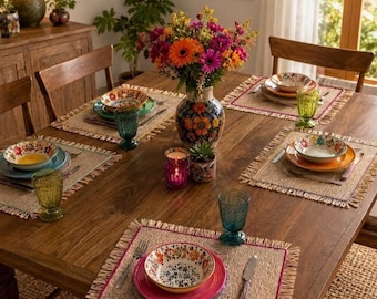 Può includere: Un tavolo da pranzo in legno apparecchiato per un pasto. Il tavolo è apparecchiato con ciotole, piatti e bicchieri a motivi floreali. Un vaso di fiori colorati è al centro. Tovagliette tessute e candele completano l'allestimento.