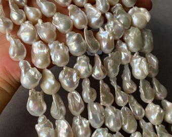 May include: A collection of irregular, baroque-shaped white pearls with a high-luster, iridescent finish. Each pearl features a unique, organic form with smooth, reflective surfaces that catch the light, creating a shimmering effect across the strand.