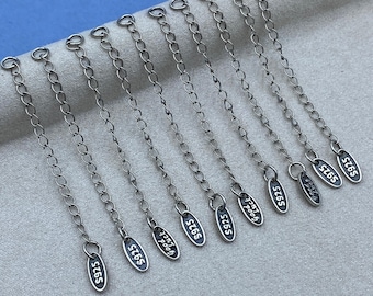 May include: A set of ten silver-toned metal necklace extender chains, each featuring a small oval tag at the end. Each tag is engraved with the text S925 on one side and Good Luck on the other, with a jump ring at the opposite end.