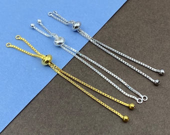 May include: Three adjustable slider chains for jewelry making. One chain is gold-toned, and two chains are silver-toned. Each chain features a box link design, a sliding bead mechanism for length adjustment, and small end caps at the tips.