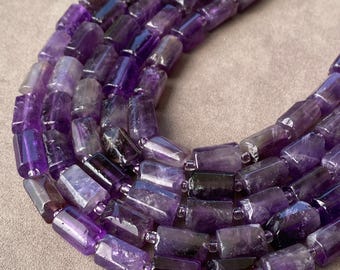 May include: A multi-strand necklace composed of polished, cylindrical amethyst beads in varying shades of deep purple and violet. The beads are strung together, showcasing natural color variations and translucent qualities within the stone segments.