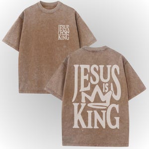 A beige t-shirt with the text "JESUS IS KING" printed on the back.