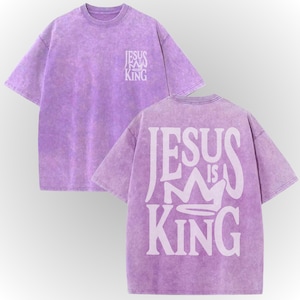 A purple t-shirt with the text "JESUS IS KING" printed on the back.