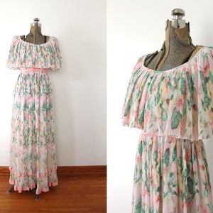 May include: A long, white maxi dress with a floral print in shades of pink, green, and yellow. The dress has a ruffled neckline and a cinched waist.