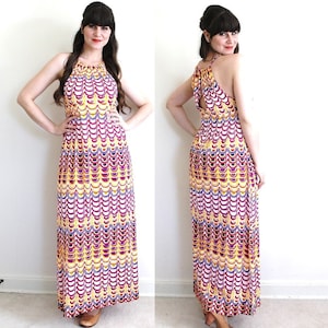 May include: A maxi dress with a halter neckline and a colorful geometric pattern. The dress is made of a lightweight fabric and has a flowing silhouette.