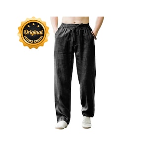 Könnte beinhalten: Schwarze Leinenhose mit Kordelzugbund. Die Hose hat Taschen und eine lockere Passform. Ein goldenes Siegel mit dem Wort "Original" befindet sich in der oberen linken Ecke.