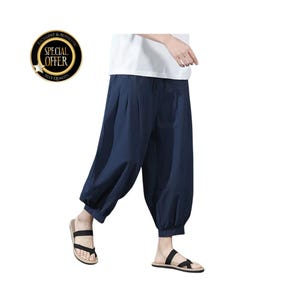 May include: Navy blue harem pants with a relaxed fit. The pants have a gathered ankle and a pleated front. The person is wearing black sandals. A gold and black circular badge with the words "SPECIAL OFFER" is in the upper left corner.