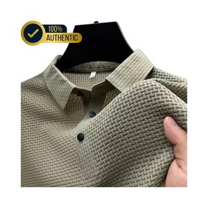 May include: A light green button-down shirt with a textured weave pattern. The shirt has a classic collar and black buttons. The image includes a gold and blue badge that says "100% AUTHENTIC".