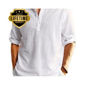 Può includere: Camicia bianca a maniche lunghe con colletto alla coreana e maniche arrotolate. La camicia ha un aspetto strutturato e una paramontura abbottonata. È visibile un distintivo oro e nero con la scritta "LIMITED LIFETIME WARRANTY".