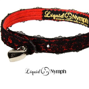 May include: A black and red leather choker with a heart-shaped lock and the text "Liquid & Nymph Genuine Leather Made in the USA".