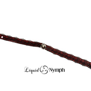 May include: A black and red lace choker with silver heart-shaped charms and a silver bell charm.