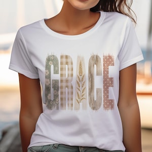 Może przedstawiać: Biały t-shirt z krótkim rękawem z napisem GRACE na piersi. Każda litera ma unikalny wzór: G ma kwiatowy nadruk, R kratkę vichy, A kłos pszenicy, C usłojenie drewna, a E wzór w kropki.