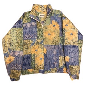 May include: A vintage jacket with a patchwork design featuring yellow floral patterns, blue and green geometric shapes, and a white zipper. The jacket has a high collar and the brand name "Dartyn" is visible on the label.