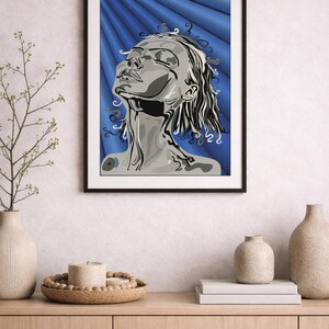 Könnte beinhalten: Gerahmter Kunstdruck in Graustufen, der eine Person zeigt, die mit geschlossenen Augen nach oben blickt. Das Kunstwerk befindet sich vor einem blauen Hintergrund mit radialem Muster. Der Druck wird über einem Holzschrank mit dekorativen Vasen und einer Kerze ausgestellt.