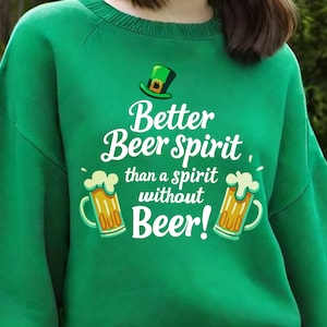 Pode incluir: Camisola verde com um gráfico branco que diz "Better Beer Spirit, than a spirit without Beer!" com uma caneca de cerveja de desenho animado de cada lado do texto.