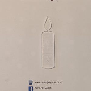 Könnte beinhalten: Klarer Kerzenförmiger Glasschmuck. Der Schmuck ist ein Ausschnitt mit einer Flamme oben. Die Worte "WATERJET GLASS" sind oben im Bild aufgedruckt. Die Website- und Facebook-Informationen befinden sich unten.