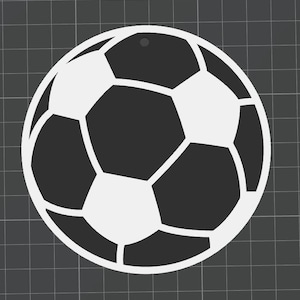 May include: A black and white soccer ball ornament. The ornament is a stylized representation of a soccer ball, featuring pentagonal and hexagonal shapes. It has a small hole at the top for hanging. The background is a dark gray grid.