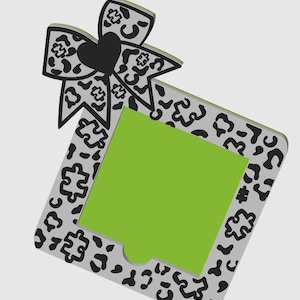 Könnte beinhalten: Ein dekoratives Geschenk-Etikett mit einer Schleife und einem Herz. Die Schleife und der Rand des Etiketts haben ein graues und schwarzes Leopardenmuster. Die Mitte des Etiketts ist hellgrün und das Herz ist schwarz.