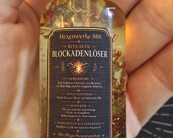 May include: A clear glass bottle containing oil and dried herbs with a gold cap. The black label reads Hexenwerke 888, RITUALÖL, BLOCKADENLÖSER, ANWENDUNG, INHALTSSTOFFE, HINWEISE, HERGESTELLT MIT INTENTION, Mit Magie bewusst wachsen, and 30 ml.