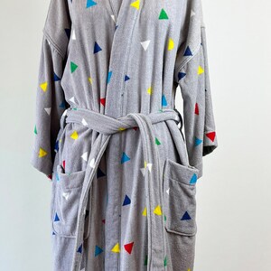 May include: A gray bathrobe with a colorful triangle pattern. The robe has a tie belt and two pockets.