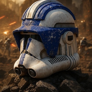 May include: A weathered white and blue helmet, reminiscent of a stormtrooper's, rests on a pile of rocks. The helmet features a blue visor and stripes, with visible wear and tear, suggesting a battle-worn aesthetic. The background shows a blurred war scene.