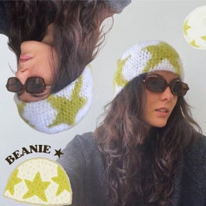 Peut inclure: Ensemble bonnet et cache-cou blanc et vert à motifs d'étoiles. Le bonnet et le cache-cou sont crochetés avec un motif d'étoiles vertes. Le mot "Beanie" est imprimé sur un fond jaune avec des étoiles.