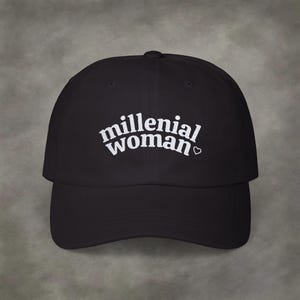 May include: A black baseball cap with white embroidered text that reads "millenial woman" with a small heart symbol.