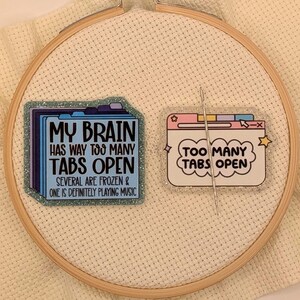 Peut inclure: Deux &eacute;pingles d&eacute;coratives avec les textes "MY BRAIN HAS WAY TOO MANY TABS OPEN" et "TOO MANY TABS OPEN" sur un cercle de broderie. La premi&egrave;re &eacute;pingle est un design de dossier bleu, et la seconde est une fen&ecirc;tre de navigateur.