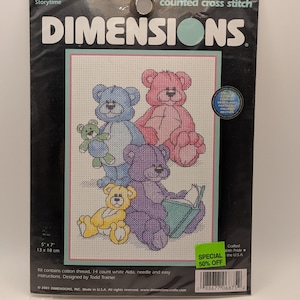 May include: A Dimensions counted cross stitch kit titled Storytime, featuring a pattern of four colorful teddy bears. The package includes cotton thread, 14 count white Aida fabric, a needle, and instructions for a 5 inch by 7 inch finished design.