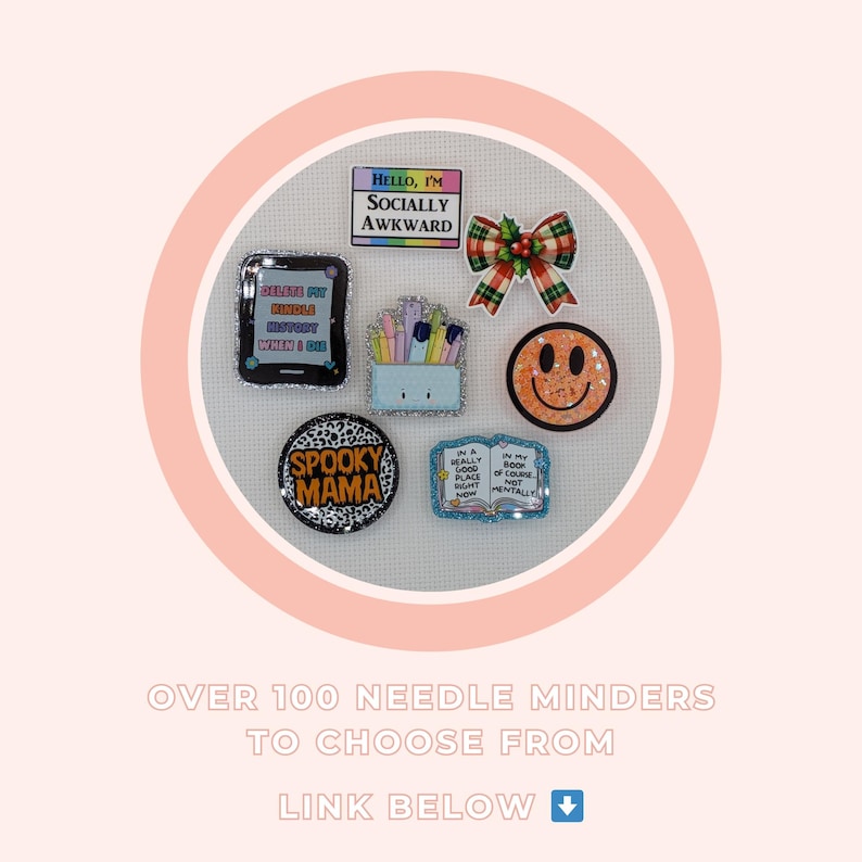 K&ouml;nnte beinhalten: Eine Sammlung dekorativer Nadelhalter mit verschiedenen Designs, darunter ein Smiley, eine Schleife und Texte wie "Hello, I'm Socially Awkward" und "Spooky Mama". Die Nadelhalter sind auf einer wei&szlig;en Oberfl&auml;che angeordnet.