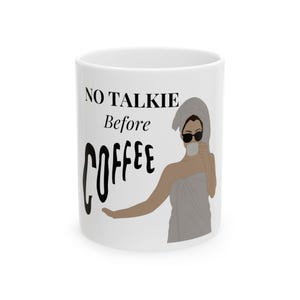 Könnte beinhalten: Weiße Keramik-Kaffeetasse mit dem Text "NO TALKIE Before COFFEE" in Schwarz. Die Tasse zeigt eine Illustration einer Person mit Sonnenbrille und Handtuch, die eine Kaffeetasse hält. Ein lustiger, neuartiger Artikel.