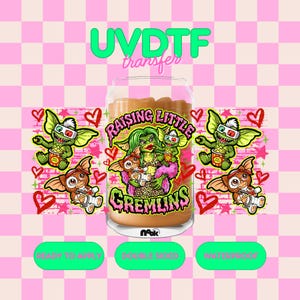 May include: A clear glass can-shaped tumbler with a "Raising Little Gremlins" design. The design features Gremlins characters, hearts, and the text "UVDTF transfer". The background is a pink and white checkered pattern.
