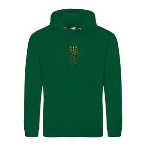 Peut inclure: Un sweat à capuche vert foncé avec un motif de hibou doré sur le devant. Le hibou est stylisé avec des détails complexes. Le sweat à capuche a une capuche et une poche avant.